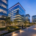 Modern Grade A office buildings with glass façades, landscaped walkways, and illuminated workspaces, representing India's growing Global Capability Centre (GCC) and commercial office market.