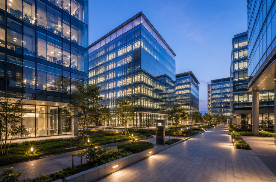 Modern Grade A office buildings with glass façades, landscaped walkways, and illuminated workspaces, representing India's growing Global Capability Centre (GCC) and commercial office market.